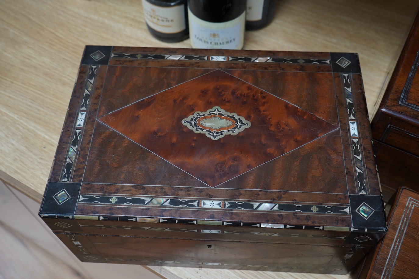 Three 19th century vanity and sewing boxes with fitted interiors to include a mother of pearl inlaid example with glass bottles, jars and mirror, largest 35cm wide. Condition - fair, some losses